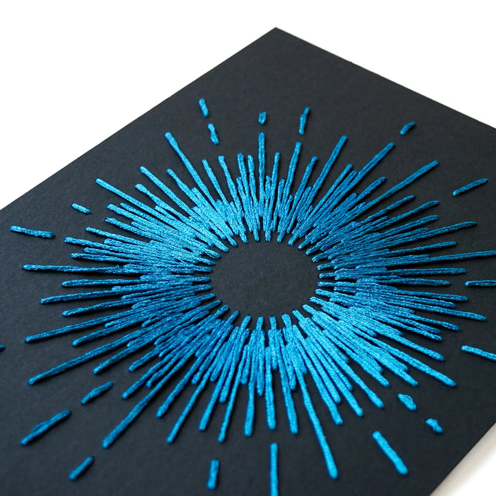 Blue embroidered design on black paper