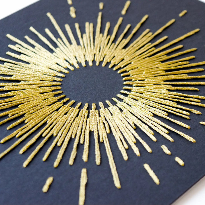Gold sunburst design on a black background