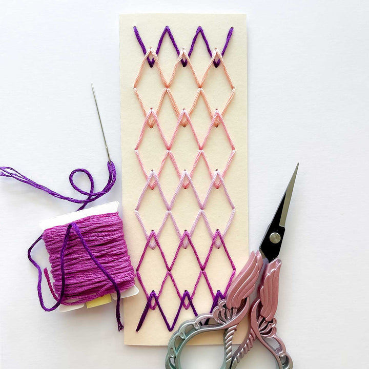 Handmade string art project with scissors and thread on a white background