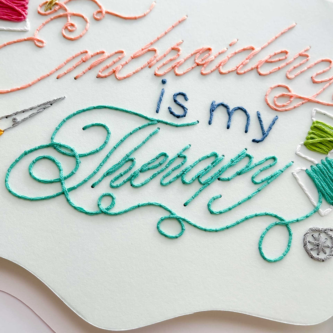 Embroidery paper with colorful thread and text 'Embroidering is my Therapy' on a white background.