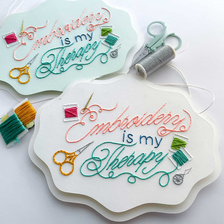 Embroidery paper with 'Embroidery is my Therapy' text and embroidery tools on a white background