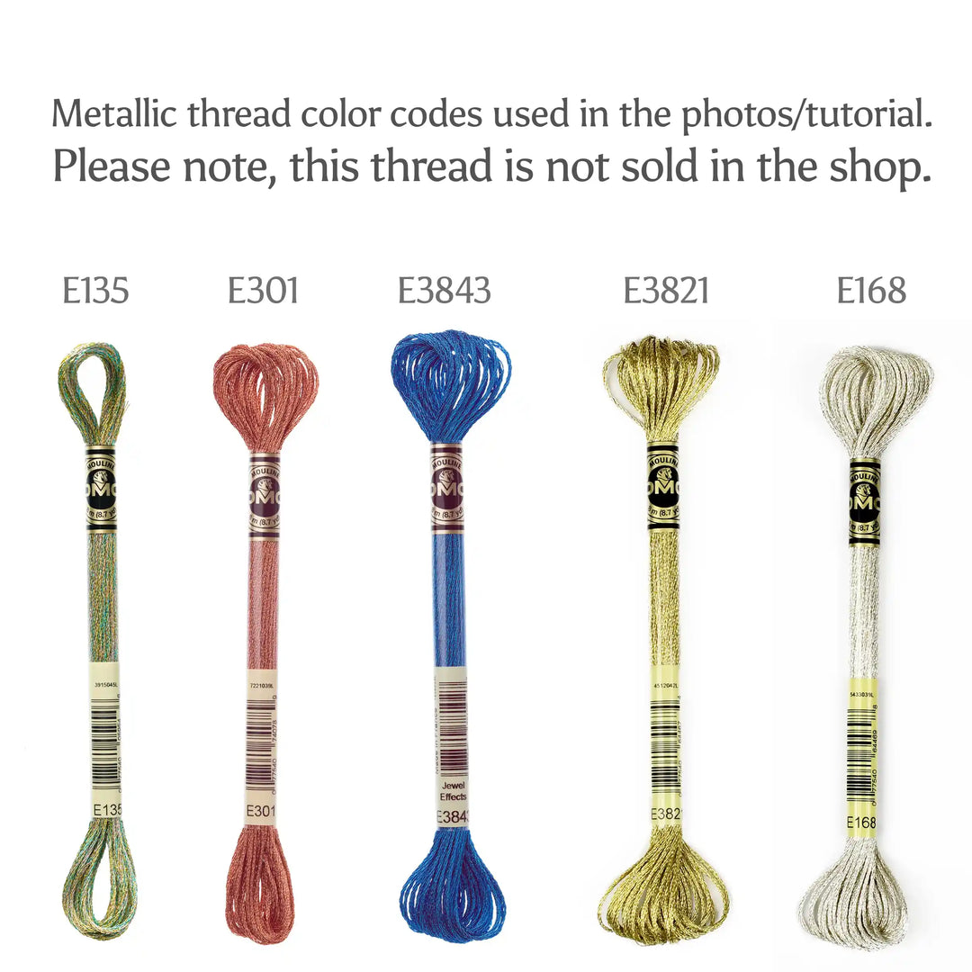 Set of metallic embroidery threads with color codes E135, E301, E3843, E3821, and E168 on a white background.