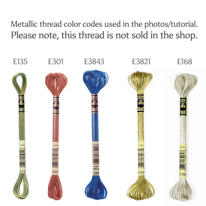 Set of metallic embroidery threads with color codes E135, E301, E3843, E3821, and E168 on a white background.
