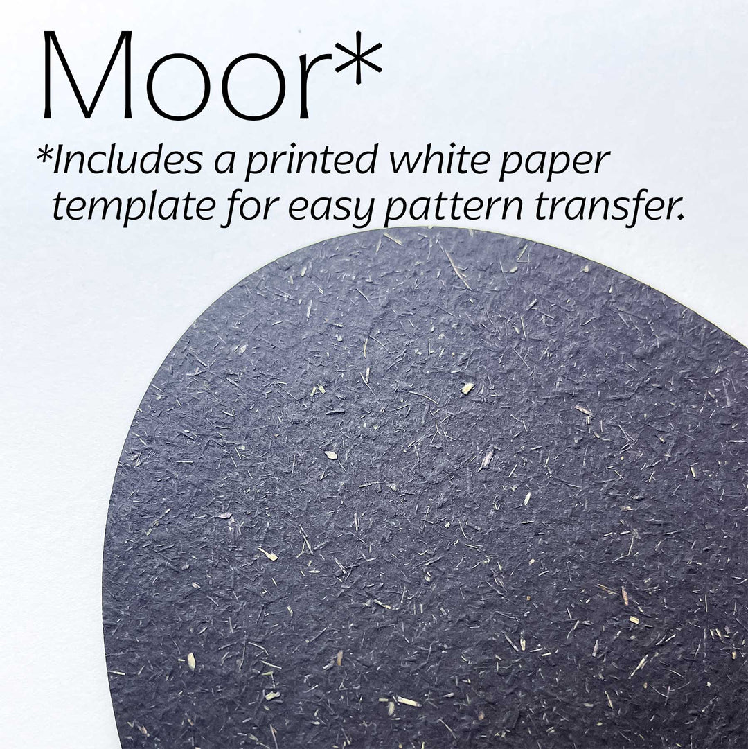 A close-up of a dark moor-colored textured paper circle on a white background, with text reading &