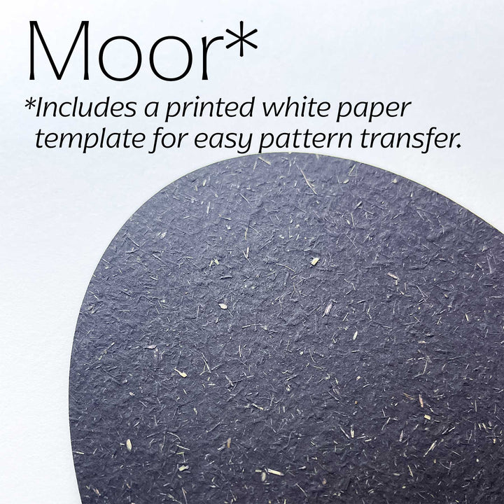 A close-up of a dark moor-colored textured paper circle on a white background, with text reading &