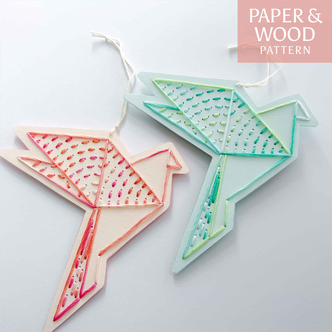 Two paper patterned bird ornaments on a light gray background